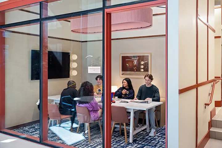 a group of students work together in an enclosed study room